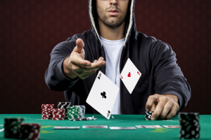 mann kaster kort på pokerbord